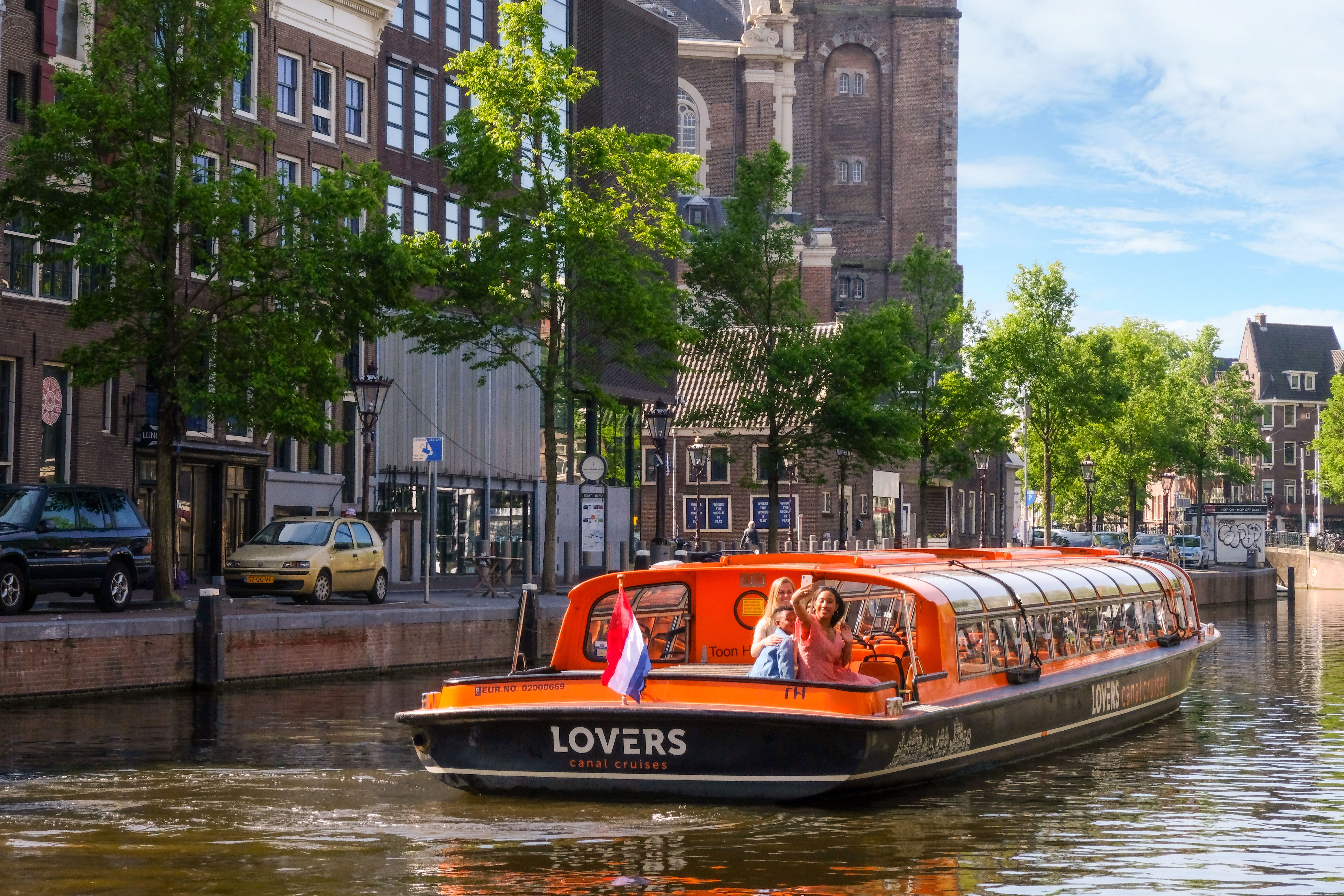 7 Tips for a Trip to Amsterdam for First Timers to The Netherlands! A boat cruising down Amsterdam canal